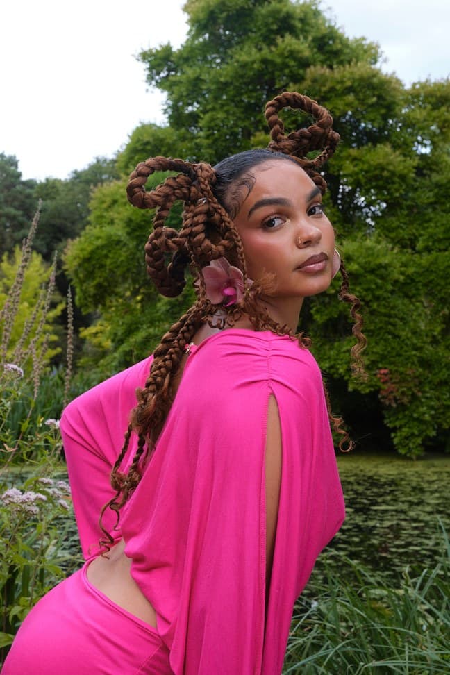 Woman in a pink dress among green trees