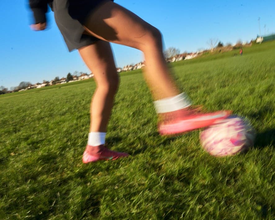 Close-up of a player striking a football on grass