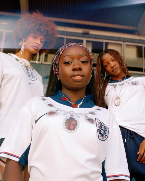 Three women in England shirts and gold jewellery