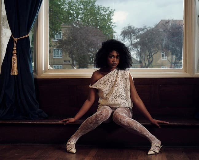 Woman in white lace sitting in a window seat