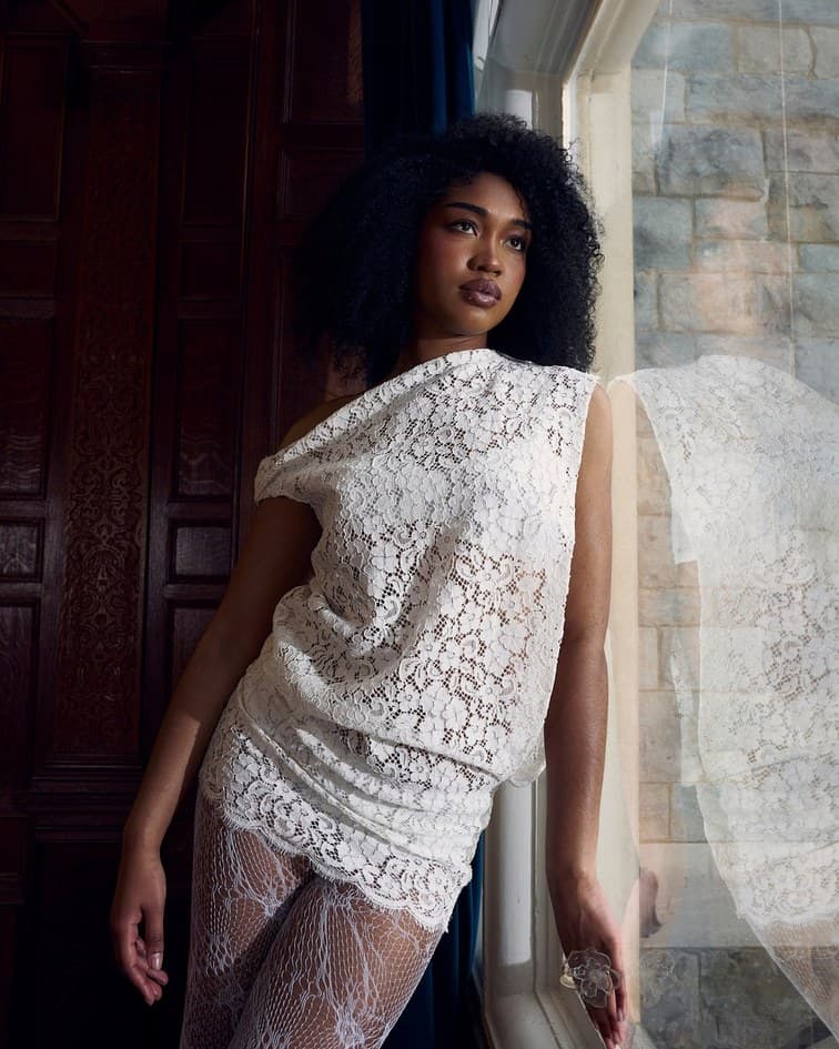 Woman in white lace by a tall window